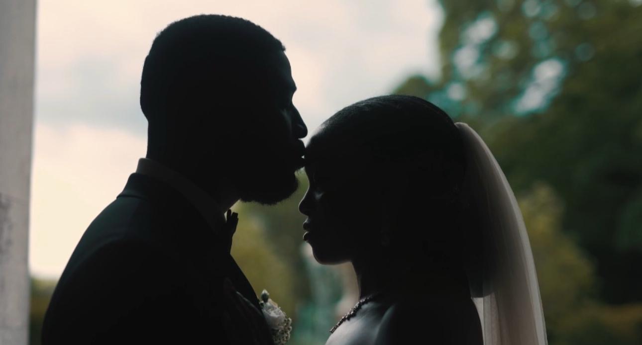 Silhouette of a groom kissing his bride's forehead at golden hour