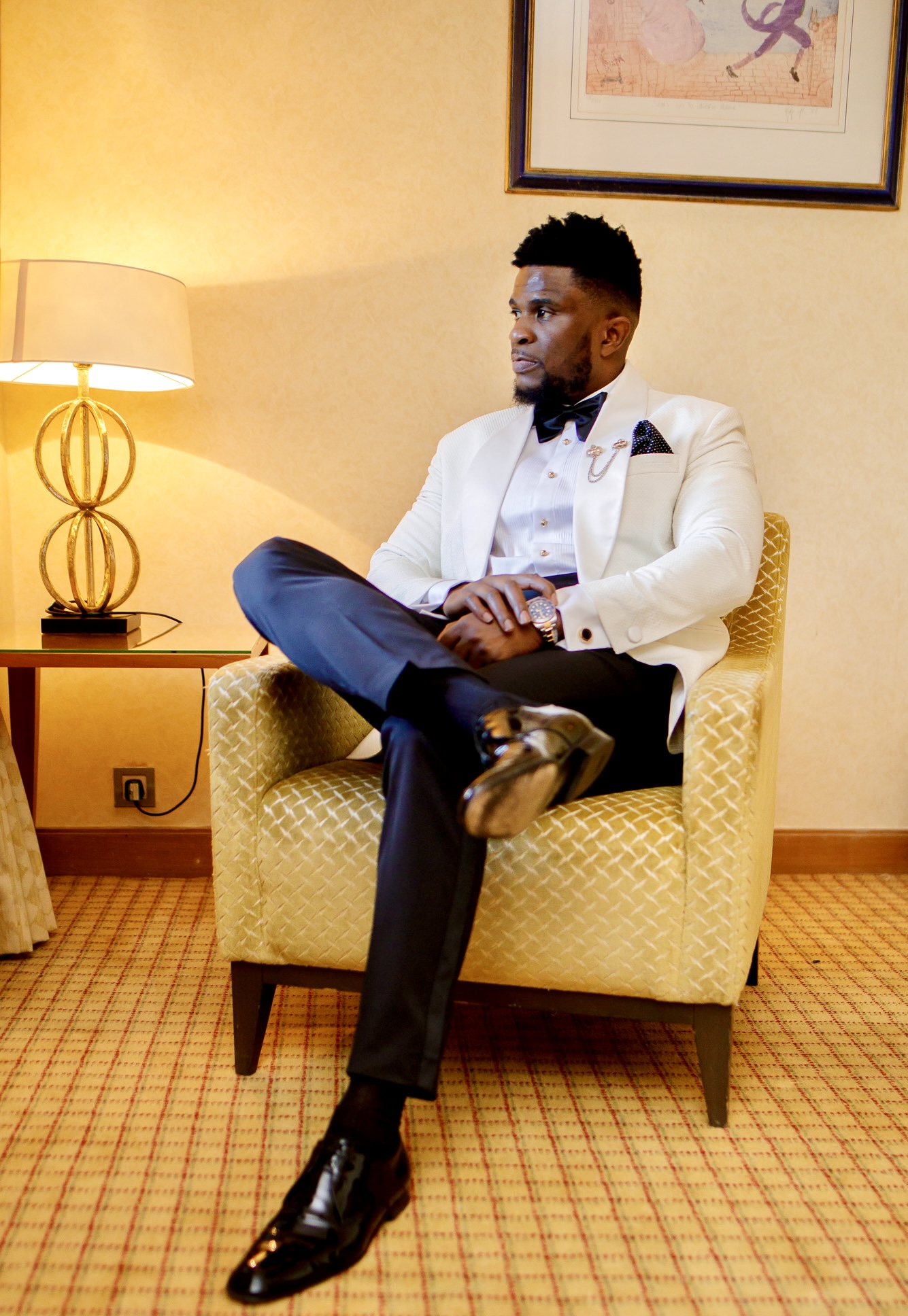 Groom in a white dinner jacket seated before the ceremony